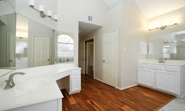 a spacious bathroom with a double vanity sink and a mirror