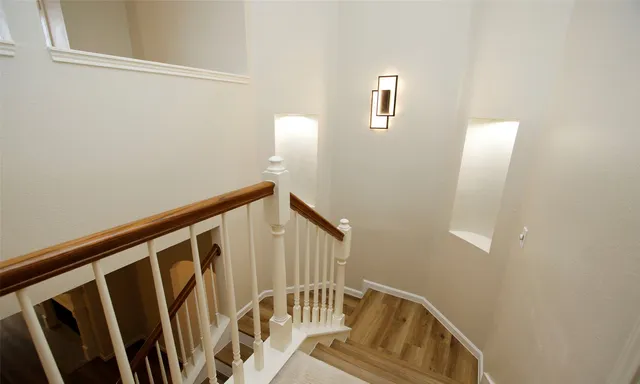 a view of staircase with wooden floor and white walls