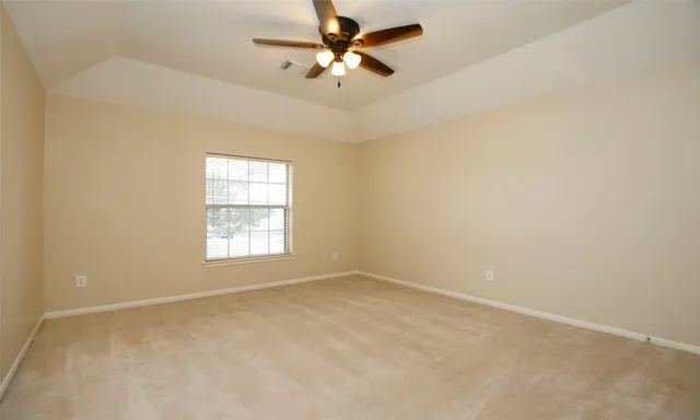 an empty room with a window and a ceiling fan