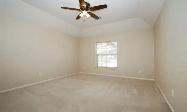 an empty room with a window and a fan