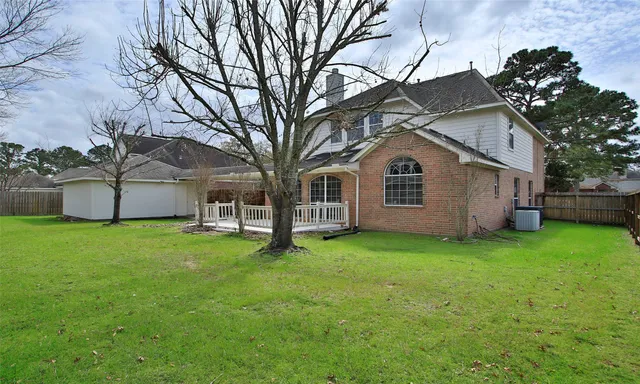 a view of a yard with a house and a large tree
