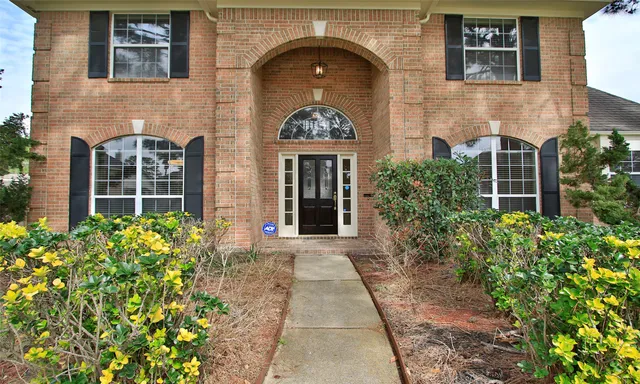 front view of a brick house with potted plants