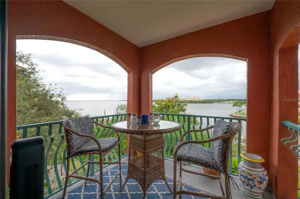 a balcony with wooden floor table and chairs
