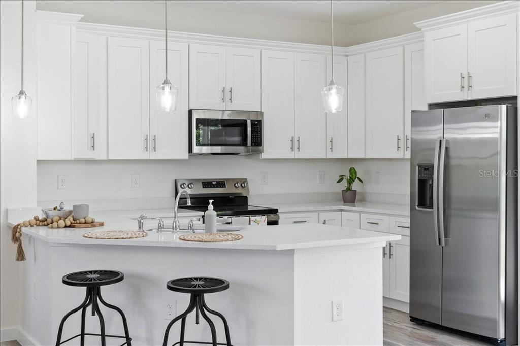 3299 Pinetree Street Port Charlotte, FL 33952 - Photo 4 of 6 a kitchen with stainless steel appliances a sink a refrigerator and cabinets