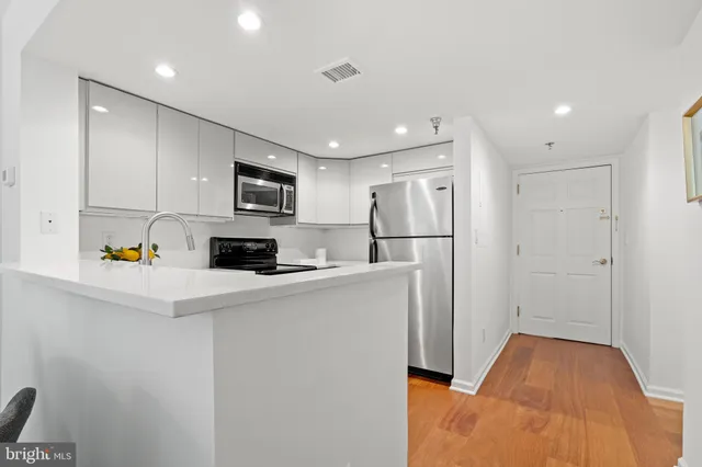 a kitchen with stainless steel appliances a refrigerator and a stove top oven