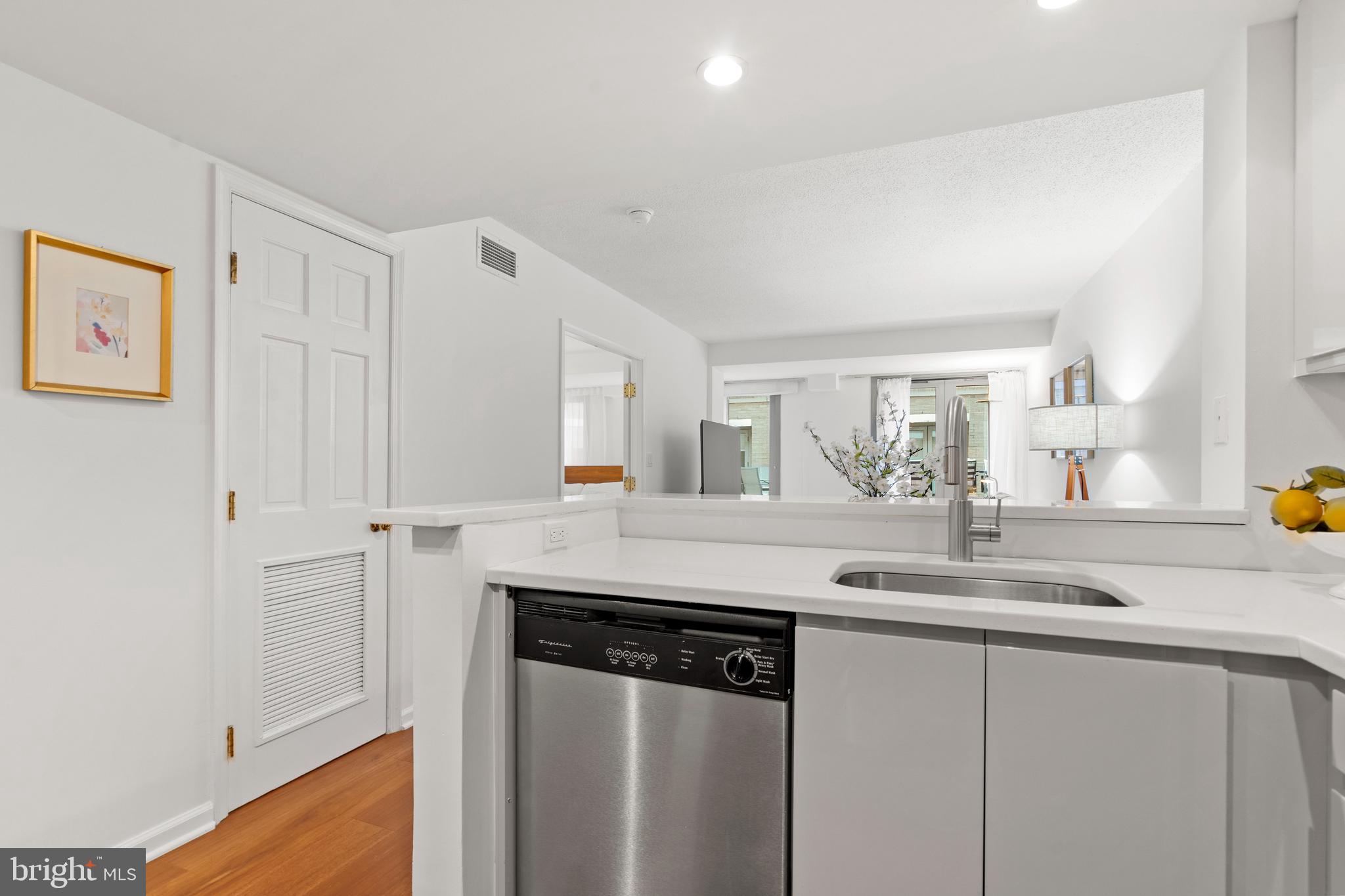 801 Pennsylvania Avenue Northwest, Unit 1125 Washington, DC 20004 - Photo 8 of 25 a kitchen with stainless steel appliances granite countertop a sink and a white cabinets
