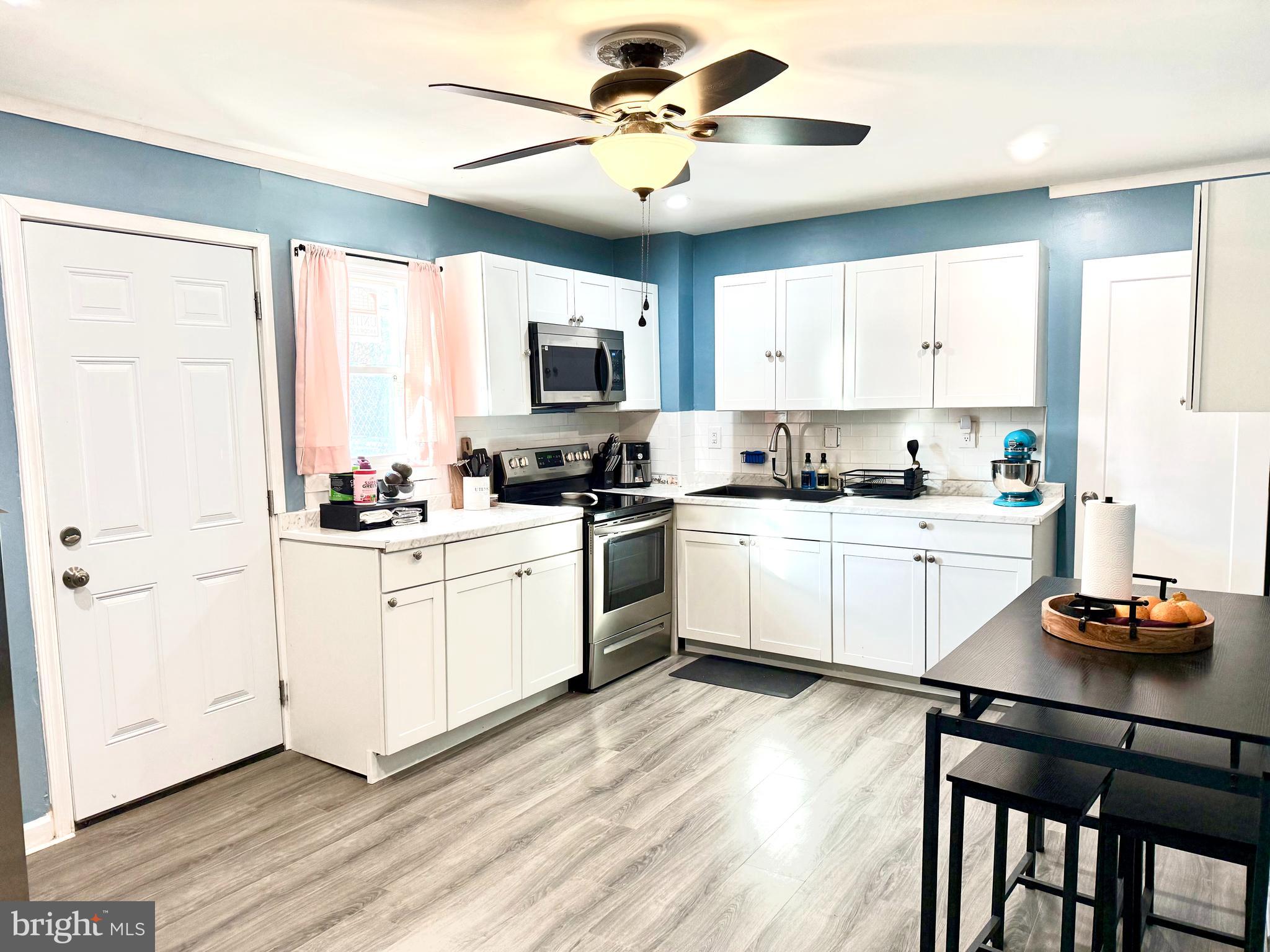 a kitchen with a sink white cabinets and white appliances