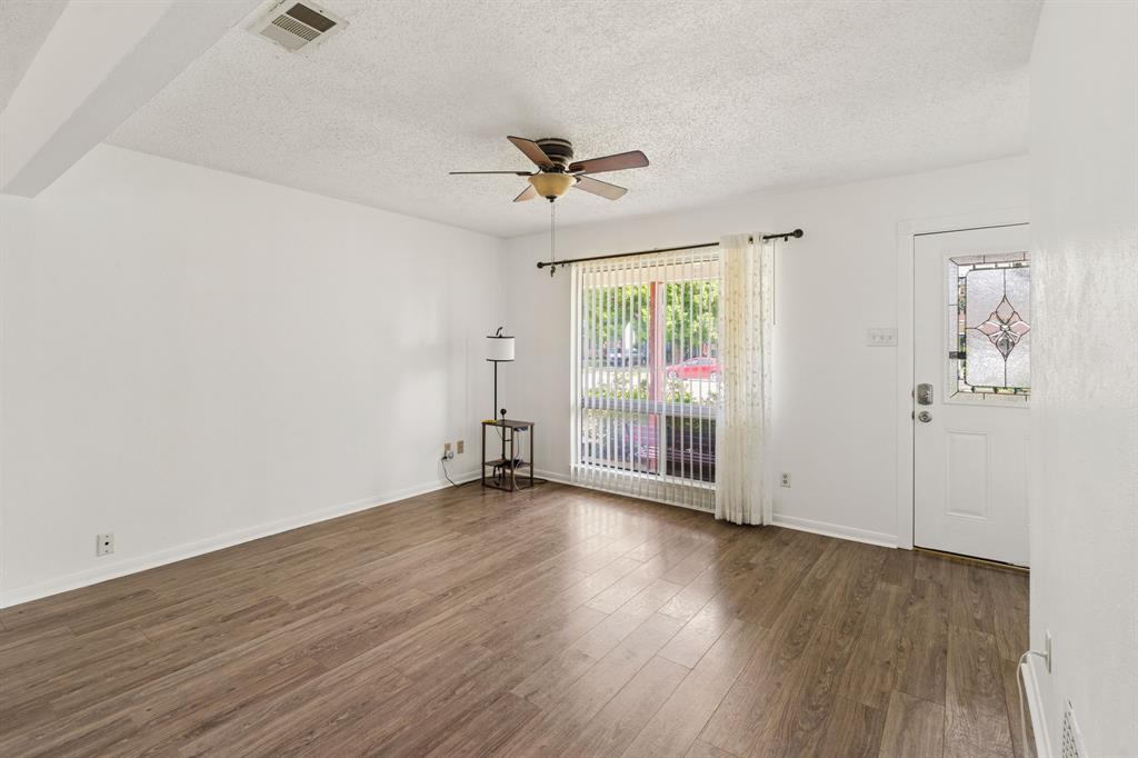 1822 Finley Road Irving, TX 75062 - Photo 9 of 38 an empty room with wooden floor fan and windows