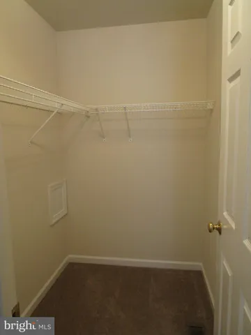 a view of staircase with railing and white walls