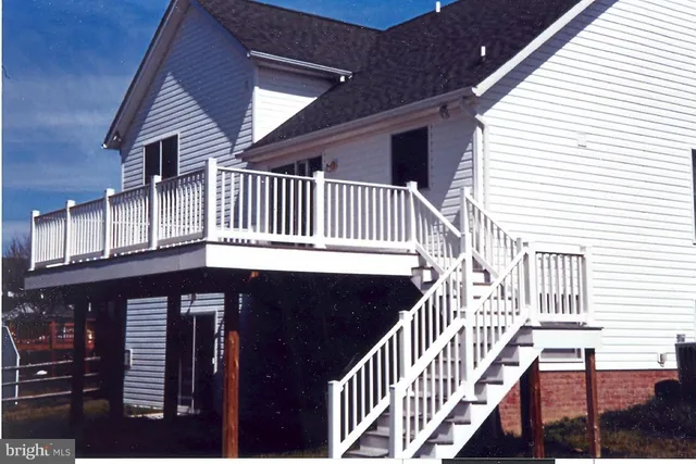 a view of an empty room with wooden floor fireplace and a window