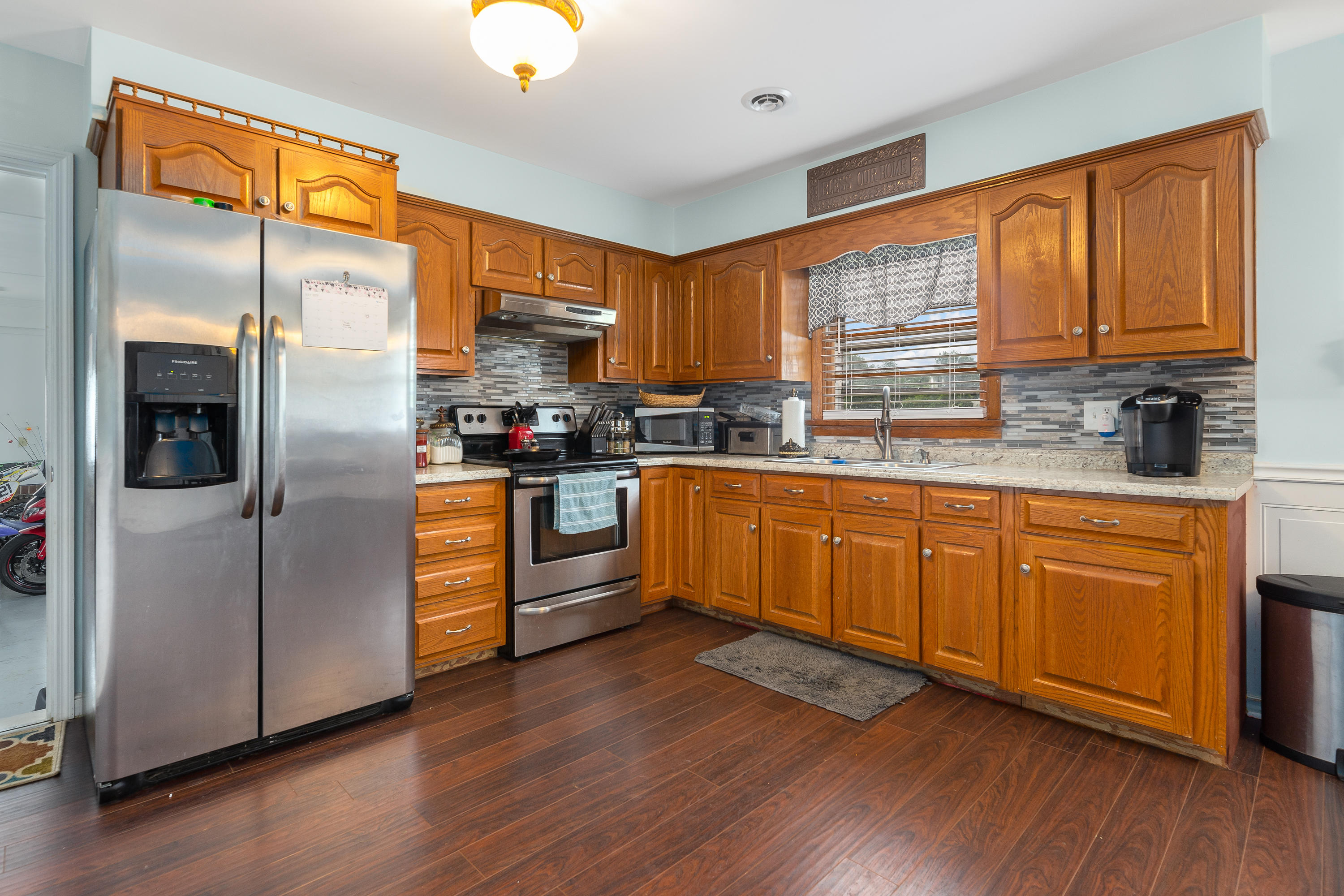 6543 Goodview Road Goodview, VA 24095 - Photo 9 of 21 a kitchen with stainless steel appliances granite countertop a refrigerator a sink dishwasher a stove with wooden cabinets and wooden floor