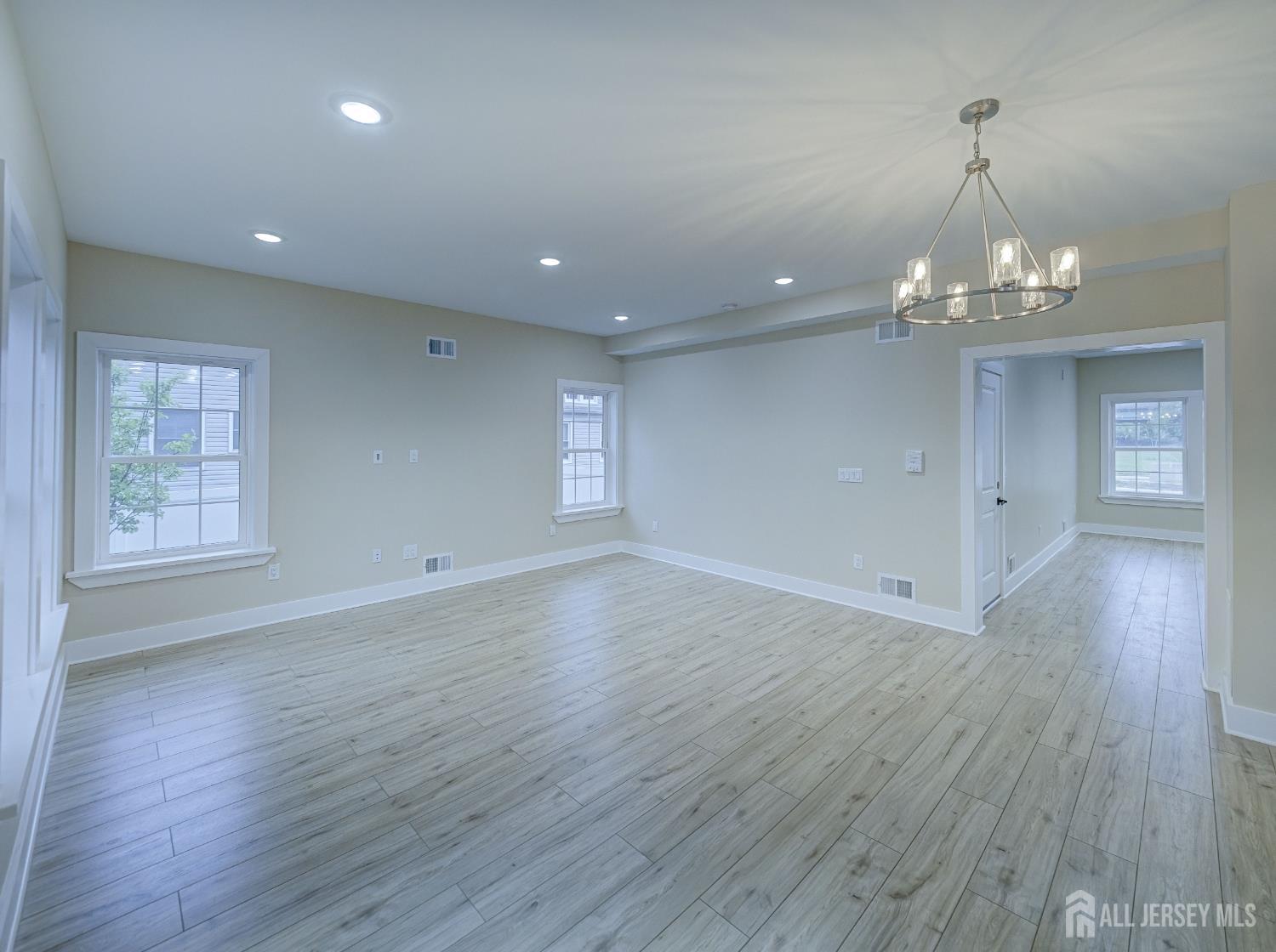8 Travers Avenue, Unit 1 Edison, NJ 08817 - Photo 3 of 19 a view of a room with wooden floors and chandelier