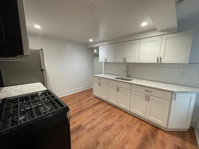 a kitchen with granite countertop a sink stove and cabinets