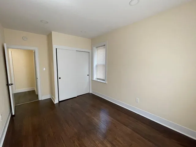 an empty room with wooden floor and closet