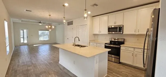 a kitchen with stainless steel appliances a sink stove and refrigerator