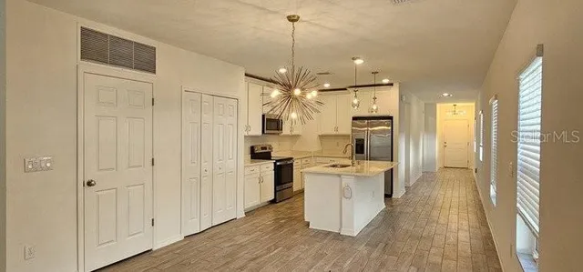 a kitchen with white cabinets and stainless steel appliances
