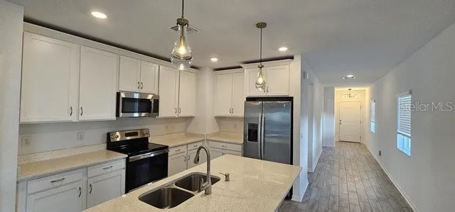 a kitchen with stainless steel appliances a stove refrigerator sink and microwave
