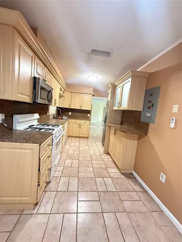 a kitchen with stainless steel appliances granite countertop a stove a sink and a microwave