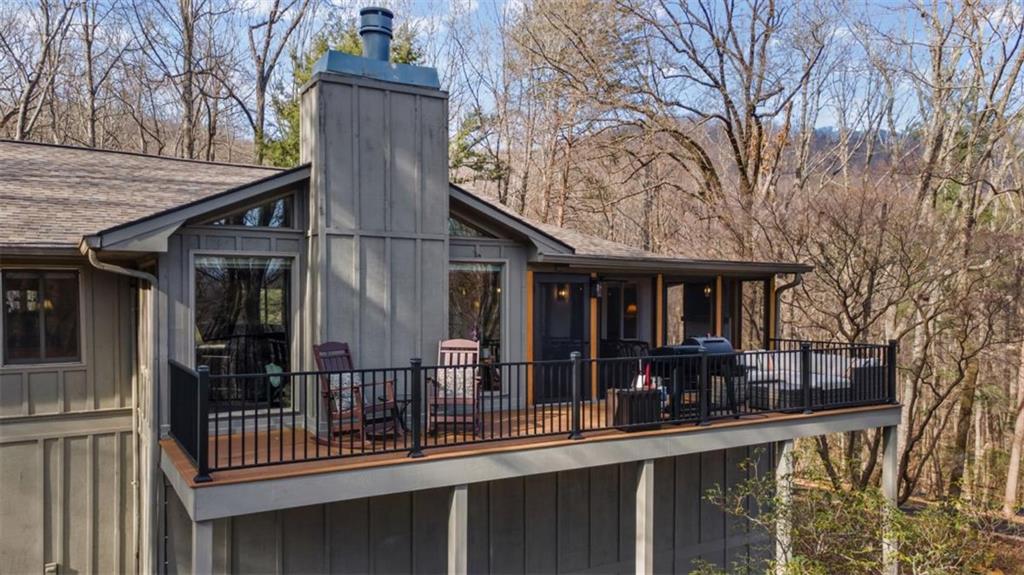 119 Soaring Hawk Circle Big Canoe, GA 30143 - Photo 33 of 50 a view of a house with large windows and wooden fence