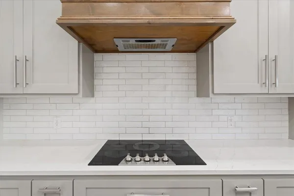 a large white kitchen with sink and stainless steel appliances
