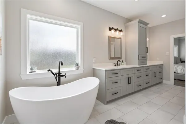 a white bath tub sitting next to a bathroom sink