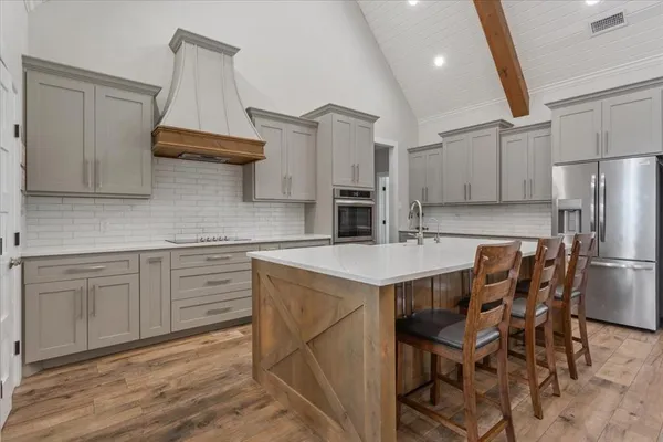 a kitchen with a table chairs refrigerator and cabinets