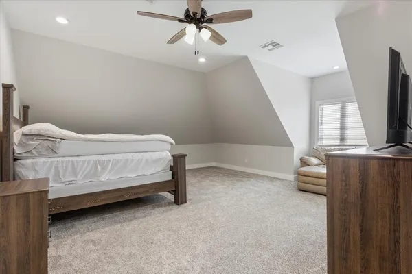 a bedroom with a bed and a flat tv screen on the dresser