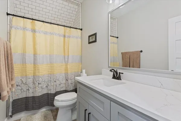 a bathroom with a sink a toilet and shower curtain