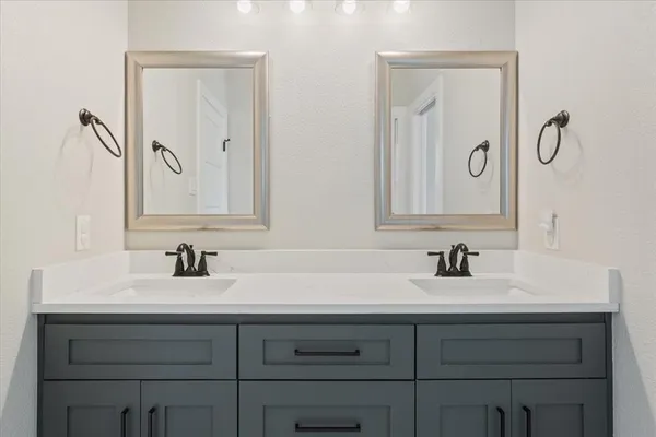 a bathroom with double vanity sink and a mirror