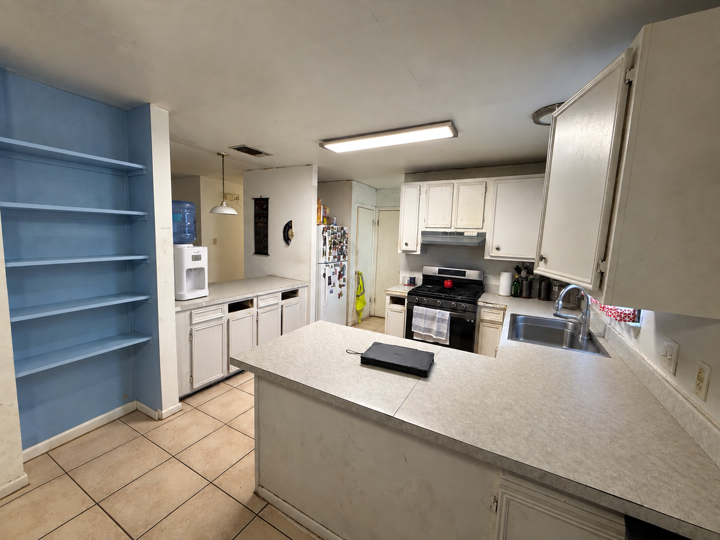 1210 Delano Street Austin, TX 78721 - Photo 7 of 12 A classic layout kitchen features tile flooring and open shelving.
