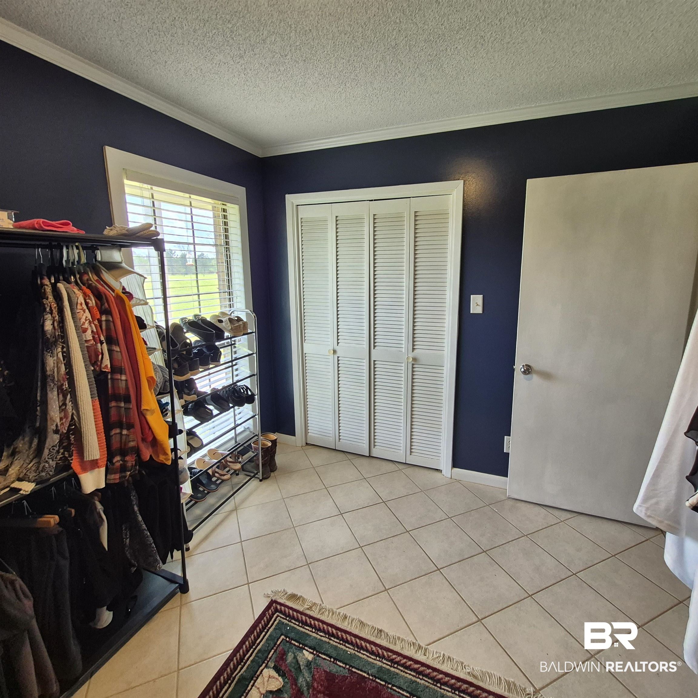 26635 Highway 41 Range, AL 36473 - Photo 30 of 74 Bedroom featuring ornamental molding, a closet, a textured ceiling, and light tile patterned floors
