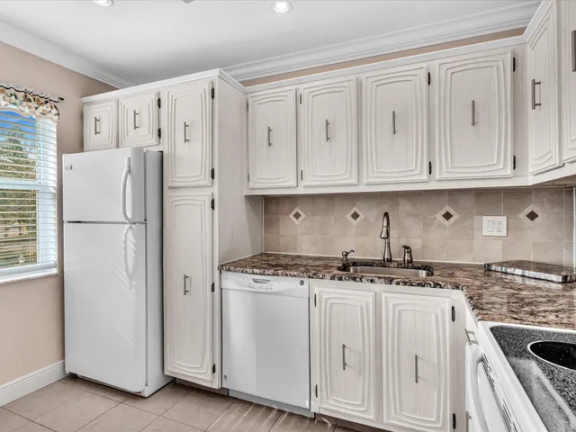 a kitchen with granite countertop white cabinets and white appliances