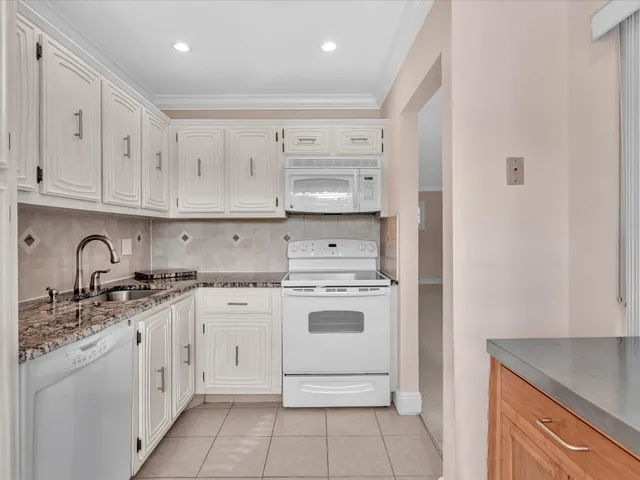 a view of kitchen with granite countertop cabinets and a large window