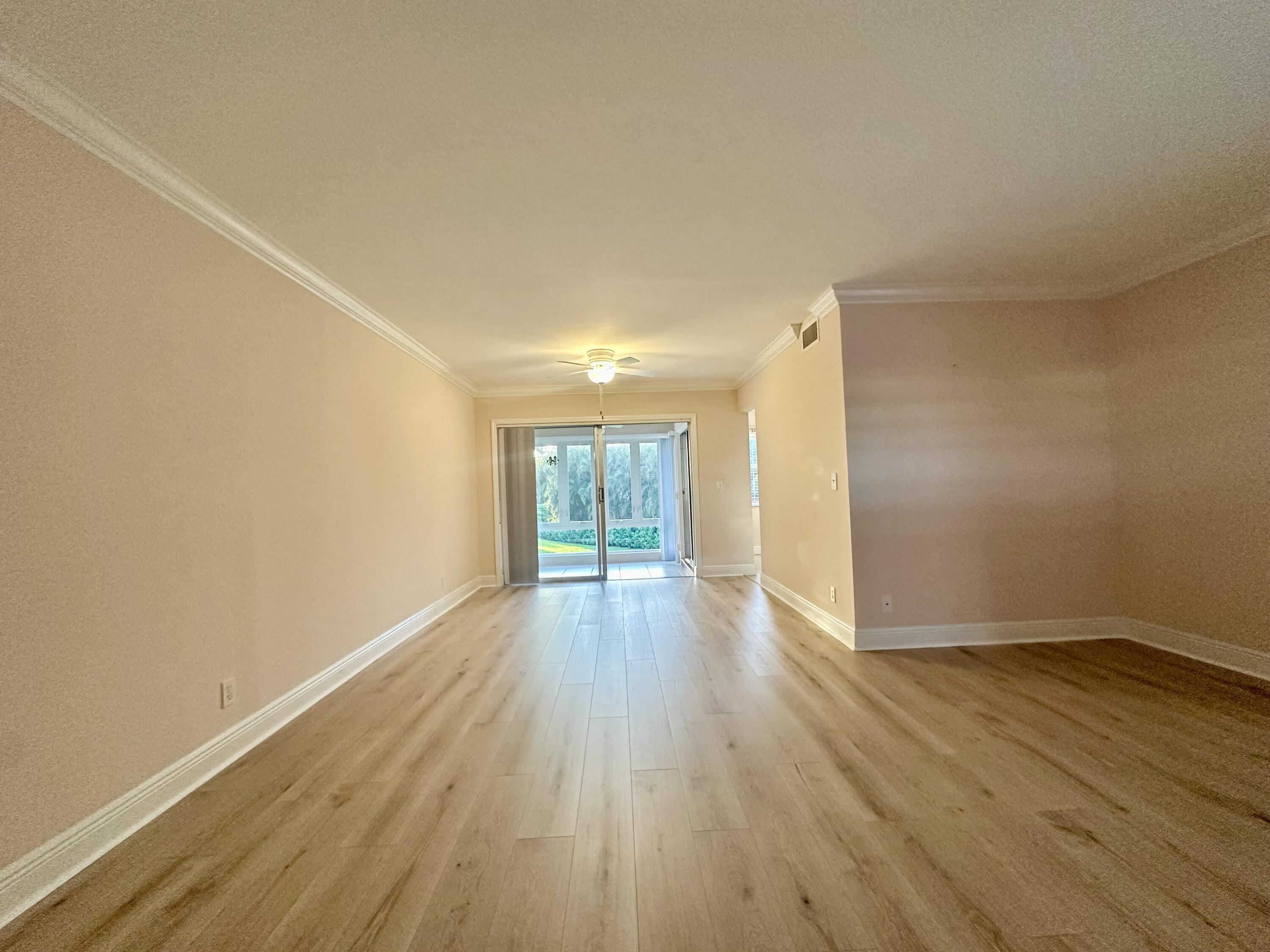 33 Colonial Club Drive, Unit 203 Boynton Beach, FL 33435 - Photo 4 of 61 a view of an empty room with wooden floor and a window