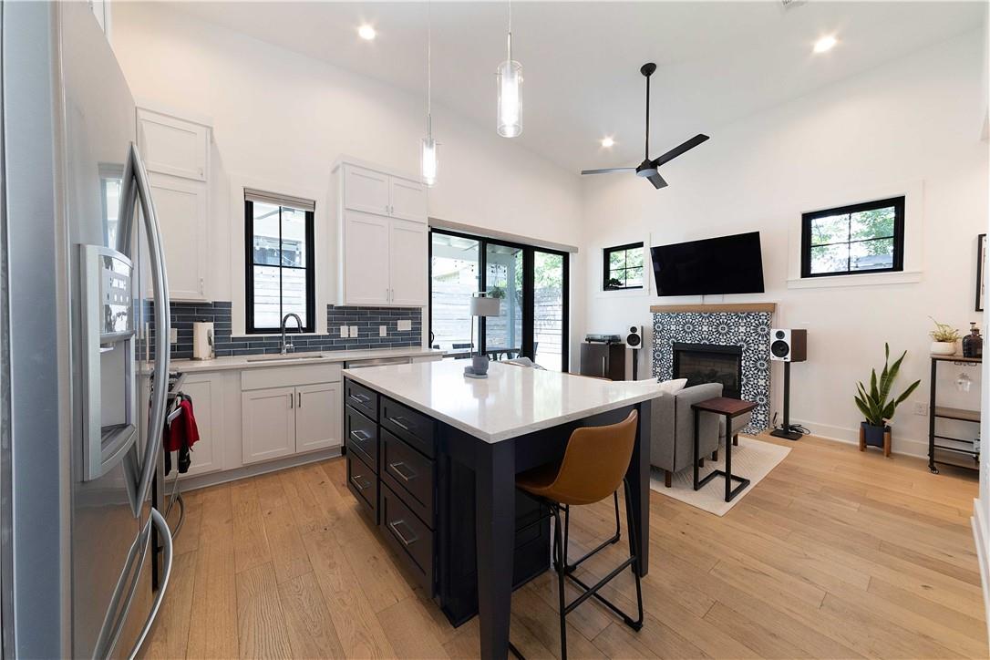 2002 East 9th Street, Unit 2 Austin, TX 78702 - Photo 11 of 32 A vibrant open-concept space features a well-appointed kitchen island flowing into a comfortable living area with a fireplace.