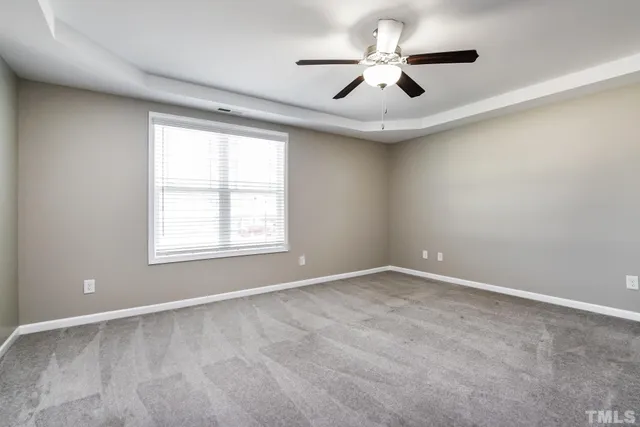 an empty room with a window and a ceiling fan