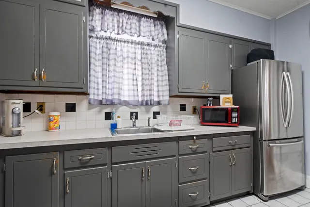 a kitchen with a sink a refrigerator and cabinets