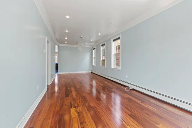 a view of empty room with wooden floor