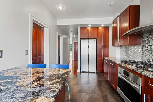 a kitchen with stainless steel appliances granite countertop a stove a sink and a refrigerator