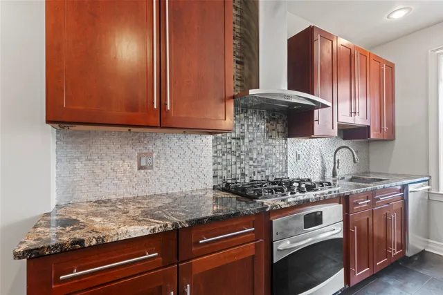 a kitchen with granite countertop cabinets and stove top oven