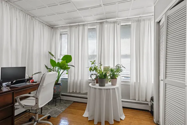 a view of a workspace with furniture and a window