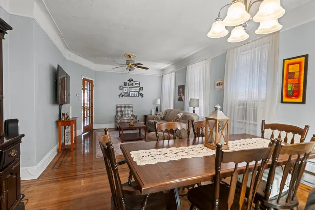 a view of a dining room with furniture a chandelier and wooden floor