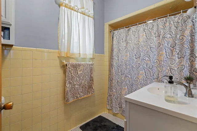 a bathroom with a sink a mirror and a shower curtain