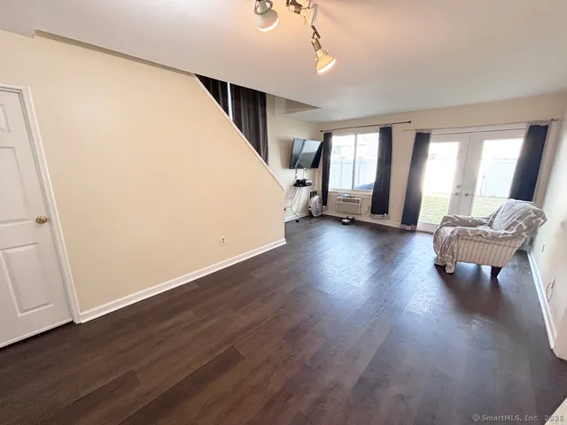 a living room with wooden floor furniture and a window