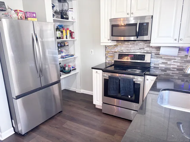 a kitchen with stainless steel appliances a refrigerator stove and microwave