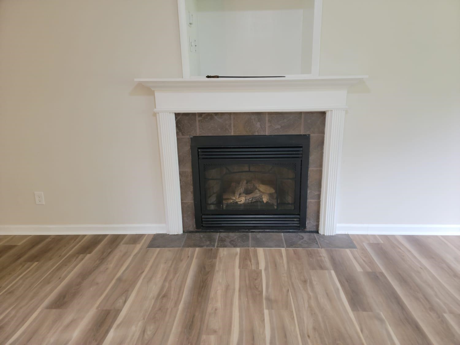 112 Pebblestone Court Willow Spring, NC 27592 - Photo 26 of 43 a view of an empty room with wooden floor and a fireplace