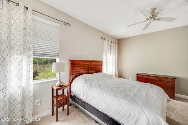 a bedroom with a bed a chandelier and a window