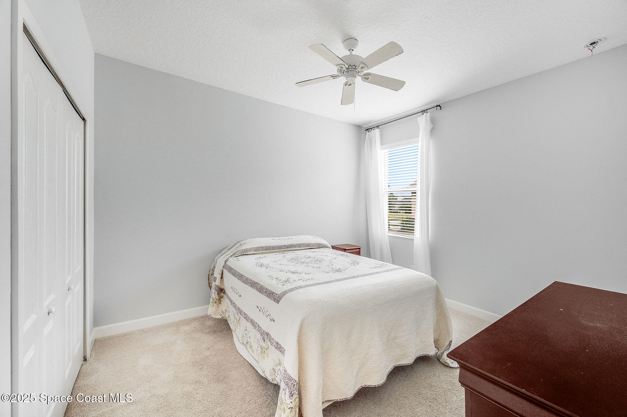 6531 Ingalls Street Melbourne, FL 32940 - Photo 16 of 46 a bedroom with a bed and a chandelier