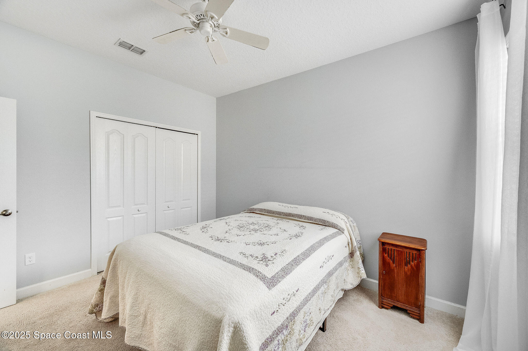 6531 Ingalls Street Melbourne, FL 32940 - Photo 17 of 46 a bedroom with a bed and a chandelier