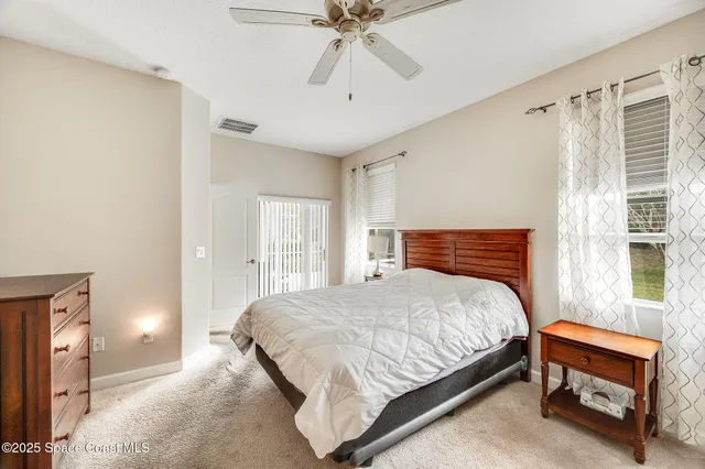 a bedroom with a bed and a ceiling fan